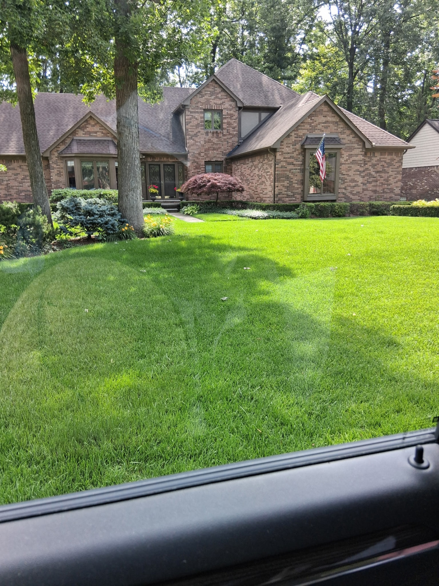 Healthy green lawn surrounding a brick Michigan home in Macomb Township, MI